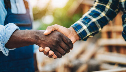 Homeowner and contractor shaking hands at construction site, symbolizing trust and partnership in home building
