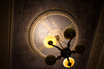 Old chandelier on the ceiling with stucco molding in a classic style