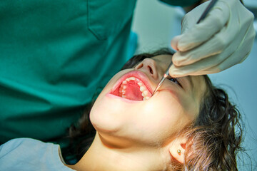 An engaged dentist conducts a routine dental check-up on a young patient, showcasing the standard of pediatric oral care