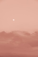 Full moon shining in a peach fuzz colored sky, color of the year 2024. Backgrounds. Copy space.
