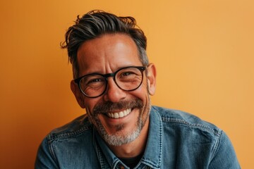 Portrait of a happy mature man with eyeglasses against orange background