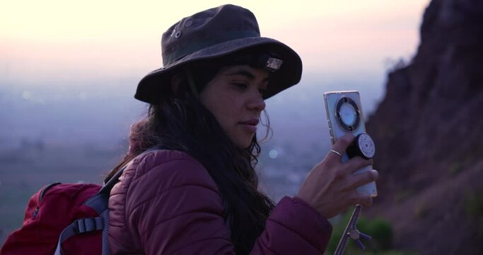 Medium shot of mexican girl taking photos in a mountain at sunrise