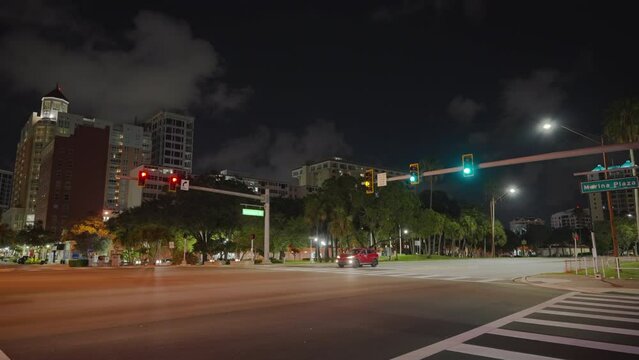 American wide multilane street intersection with traffic lights and moving cars at night. Transportation system in USA.