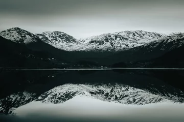 Foto auf Glas snowing mountain and lake reflection panorama in Norway © Aidan