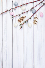 Easter banner with willow branches, pastel eggs and feathers.