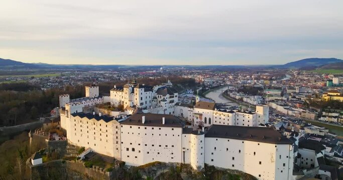 Aerial view Hohensalzburg Castle in Salzburg Austria. Ancient fortress on the top of the mountain at sunset in the landscape of the city and mountains of the Alps. High quality 4k footage