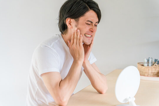虫歯・歯列矯正・歯周病・歯が気になる若い男性（歯痛）
