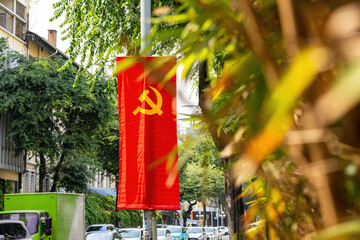 A banner with the communist symbols (hammer and sickle) on a pole in Ho Chi Min City (Saigon),...
