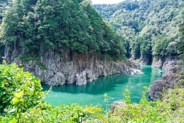 エメラルドグリーンの渓流が流れる瀞峡の情景