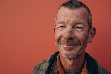 Portrait of a happy senior man on a red background. Copy space.