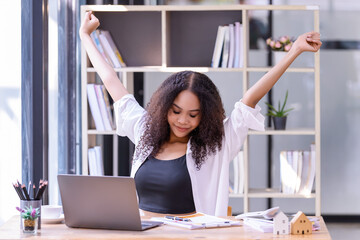 Young businesswoman office worker stretching lazily and forth relieves pain at office table...