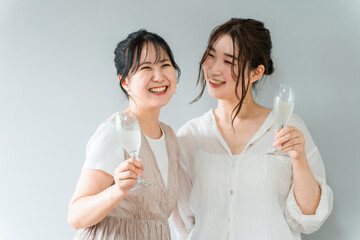 女子会・ホームパーティーでシャンパングラスを手に談笑する女性（ママ友・友人・親友）  © buritora