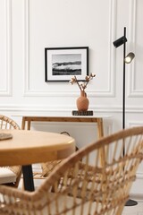 Tasty croissants on table and wicker chairs in dining room. Interior design