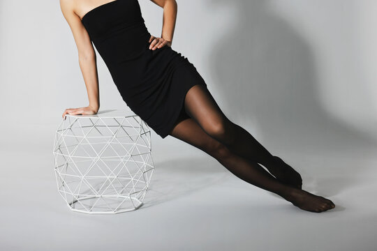 Woman with beautiful long legs wearing black tights on light background, closeup