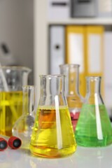 Laboratory analysis. Different glassware with liquids on white table indoors