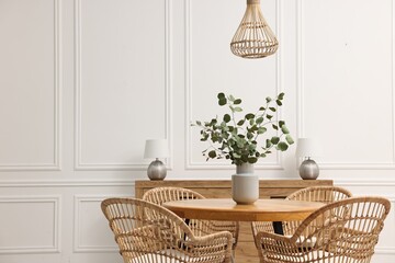 Dining room interior with comfortable furniture and eucalyptus branches. Space for text