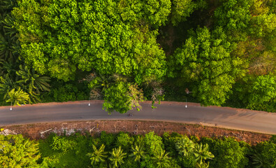 Aerial view of the road with cars passing by In the countryside with green forest and mountains....
