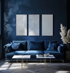 The interior of a dark blue living room with a velvet sofa, a coffee table and three vertical white layouts in white frames on the wall, a mockup of the interior