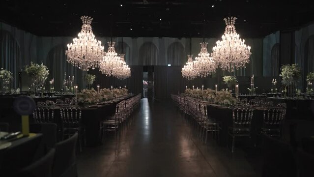 Gimbal forward movement wide shot of a wedding hall, luxury decoration, flower design, fancy interior, chandelier decorative lights, slow motion Full HD video