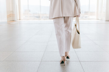 パンプス・ハイヒールを履いて歩く女性・ビジネスウーマンの後ろ姿（通勤・出勤・進む・進歩・チャレンジ）
