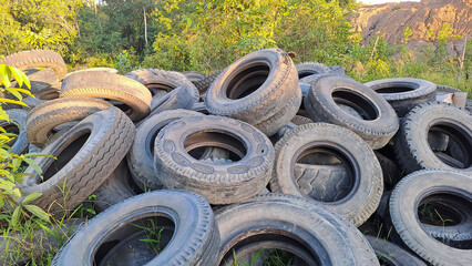 A pile of old car tires. Dump of used automobile tires. Poisonous fumes into atmosphere, environmental pollution and problem of waste recycling concept