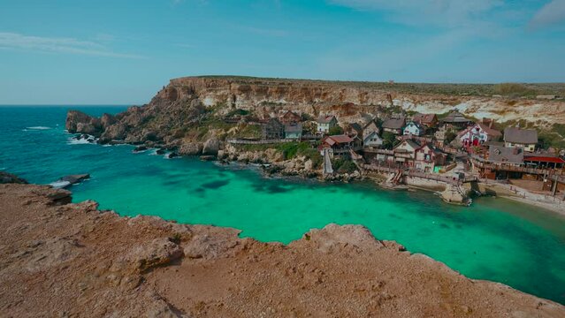 Popeye Village, rustic theme park architecture huts. Malta Island, seaside tourist attraction