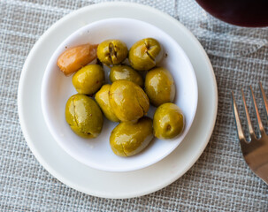 There is portion of pickled green olives in porcelain bowl. - 770266537