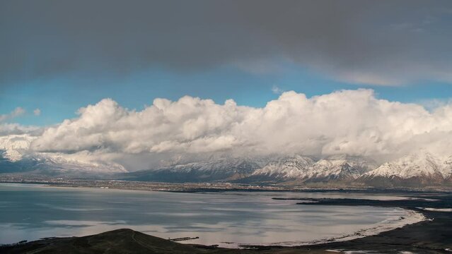 Timelapse of clouds moving over snowcapped Wasatch Mountains looking over Utah Lake from West Mountain.