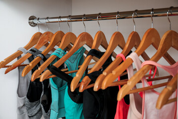 Rack with stylish sports bras in modern wardrobe