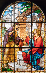 MILAN, ITALY - MARCH 6, 2024: The Jesus and the Samaritan woman  in the stained glass of the church Chiesa del Redentore by unknown artist (1933). - 770268911