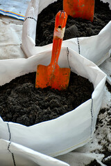 Planting bag with soil and a shovel inside © Arnupaap