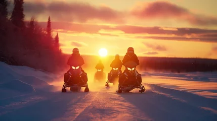 Fotobehang Group of snowmobilers riding at sunset during a winter expedition. © cherezoff