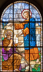 MILAN, ITALY - MARCH 6, 2024: The Jesus consigning the keys to Peter in the stained glass of the church Chiesa del Redentore by unknown artist (1933).