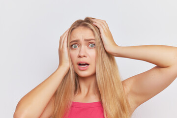 a woman is holding her head in her hands and making a surprised face