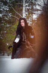 Beautiful young enchantress walking in the winter forest.