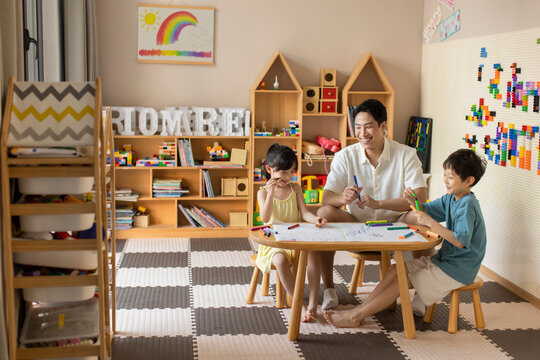 Little children painting in art class with teacher