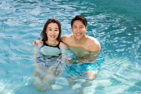 Happy young couple having fun in swimming pool