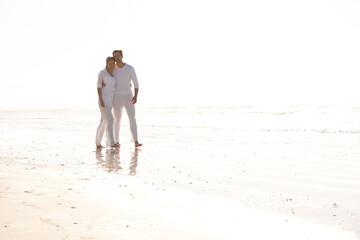Happy couple, hug and walking with beach for love, embrace or valentines day in nature. Man and woman enjoying stroll by the ocean coast or sea for holiday, date or weekend together with mockup space