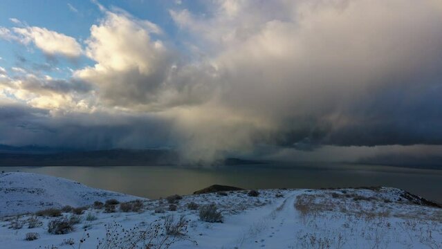 Timelapse of clouds moving through the sky in winter landscape viewing Utah Lake from snow covered West Mountain.
