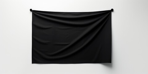 A black flag hanging on a white wall. The flag is hanging from a hook and is not attached to anything else