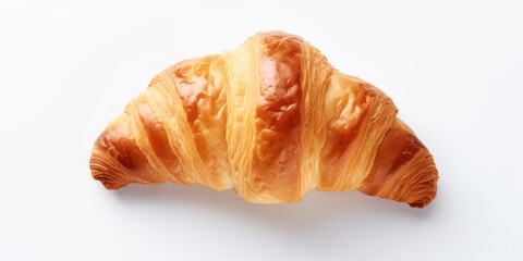A croissant is sitting on a white background. The croissant is golden brown and has a slightly crispy texture
