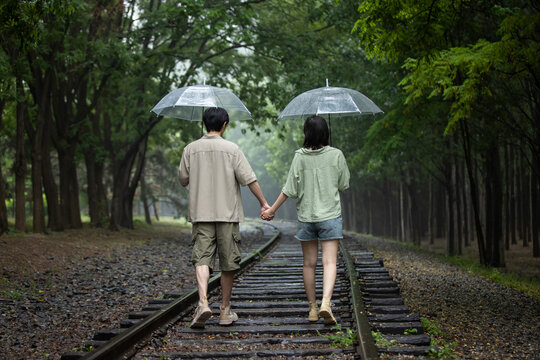 Young couple holding umbrellas
