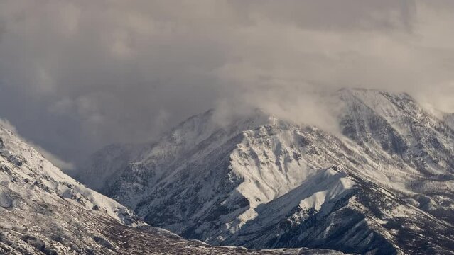 Timelapse of clouds blowing up snow capped Bald Mountain in Santaquin Utah.