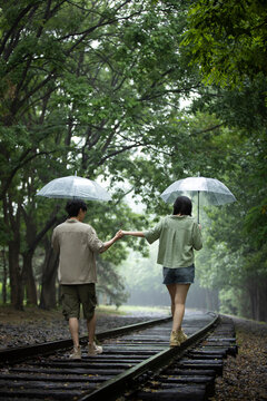 Young couple holding umbrellas