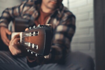 man practicing acoustic guitar at home - obrazy, fototapety, plakaty