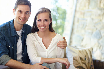 Home, couple and portrait for love, embrace and romance or care on couch in living room. Happy people, relax and smile for pride in relationship or commitment, loyalty and connection on hug date