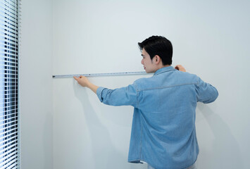 Asian man measuring and repairing houses.