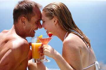 Couple, happy and toast with cocktail by swimming pool with care, vacation and love in summer. Man, woman and smile by ocean with drink, alcohol or outdoor in sunshine, water and holiday in Naples
