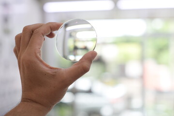 person holding a glasses lens
