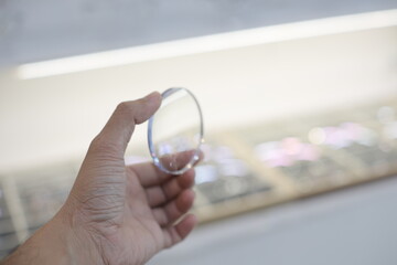 close up of hand holding a glasses lenses 